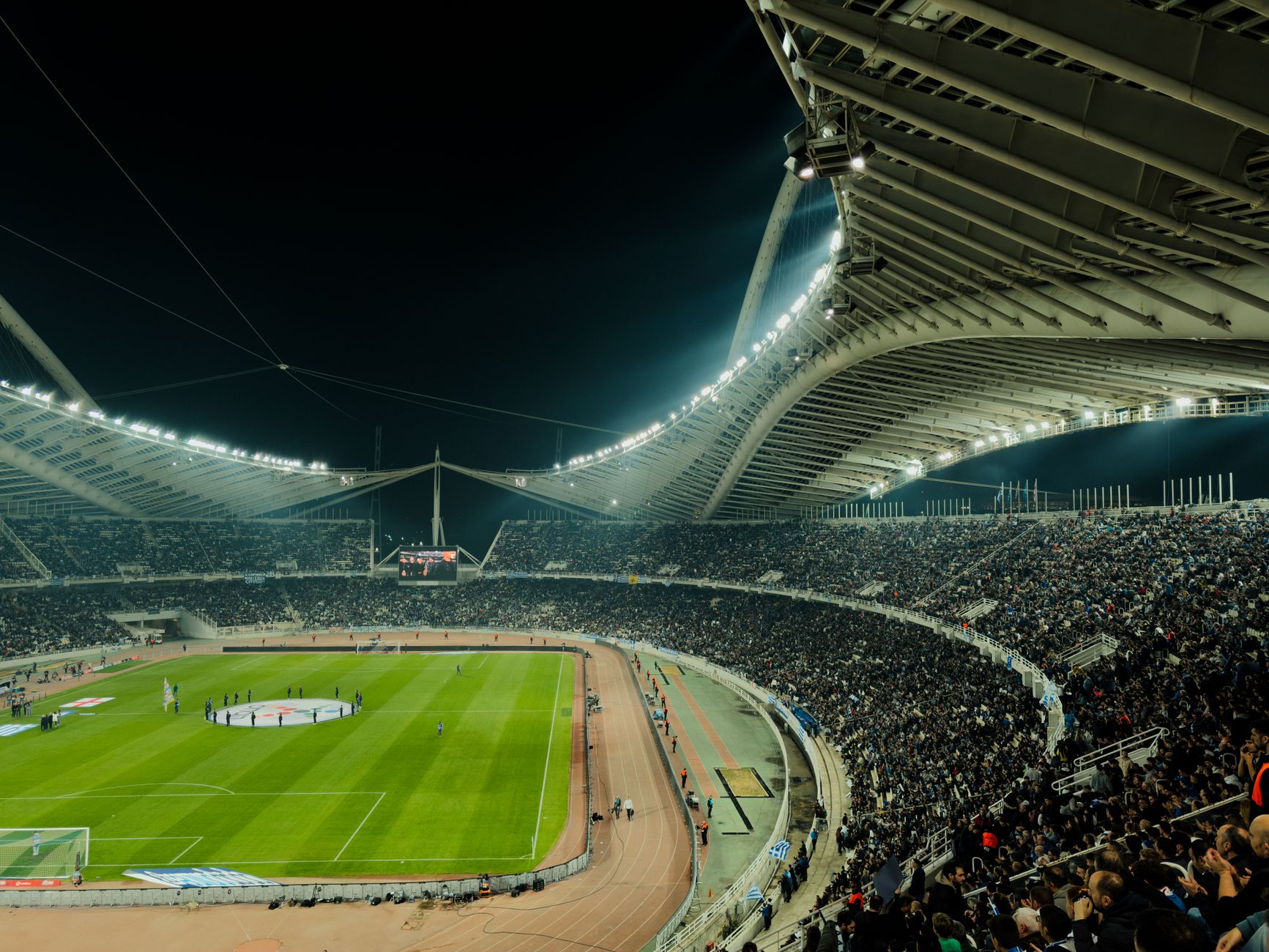 A crowded soccer stadium under bright lights at night, capturing the excitement of a live sports event.