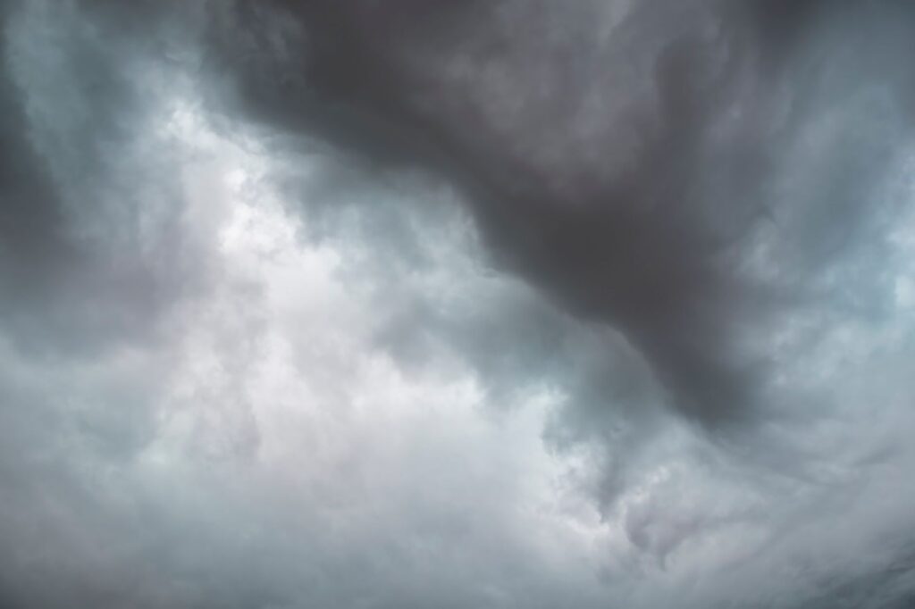 Dramatic storm clouds forming in the sky, signaling impending rain.