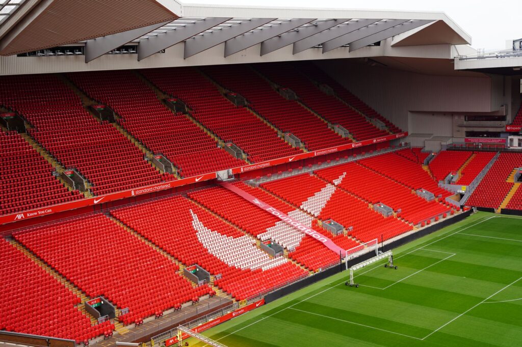 Aerial view of Anfield Stadium's iconic red seats and pitch, showcasing its architecture and design.