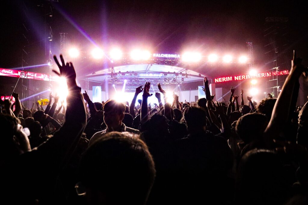 Energetic crowd enjoying a live concert under bright stage lights in Guwahati, India.