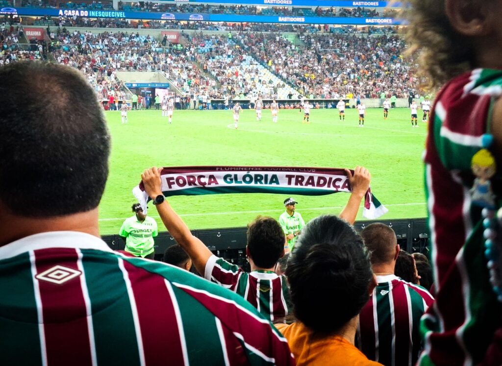 Cheering crowd at Maracanã Stadium supporting Fluminense FC during an intense football match.
