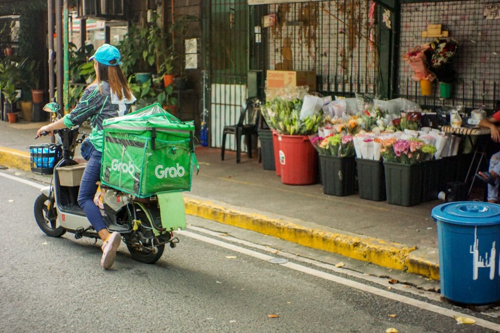 A Grab delivery rider passes by a flower shop in Sta Cruz, Manila.