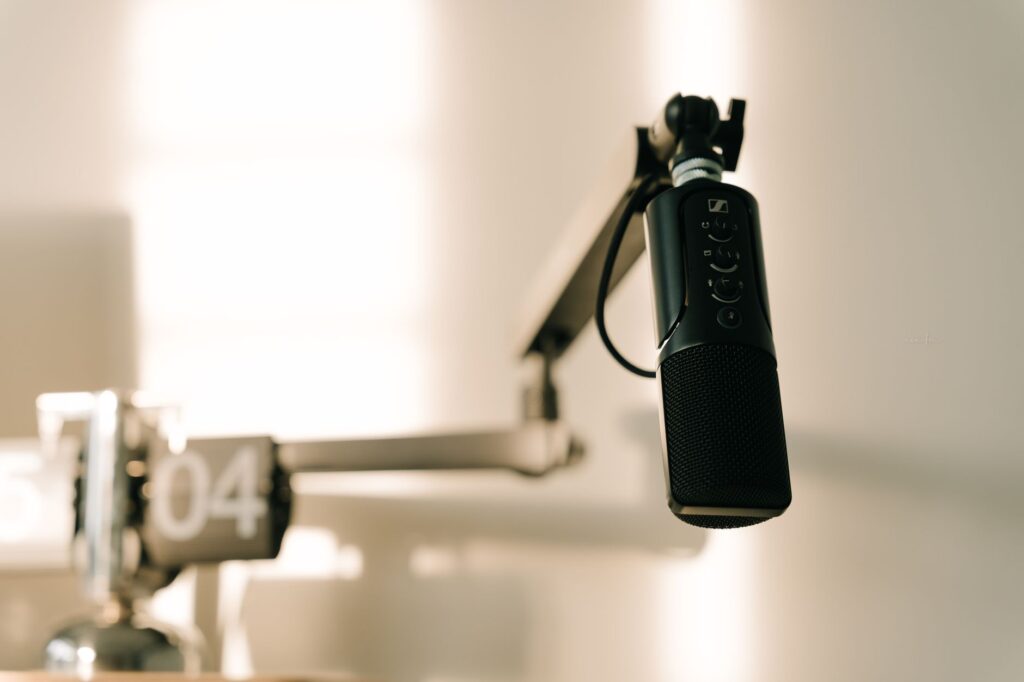A sleek professional microphone on a boom arm in a minimalist studio.